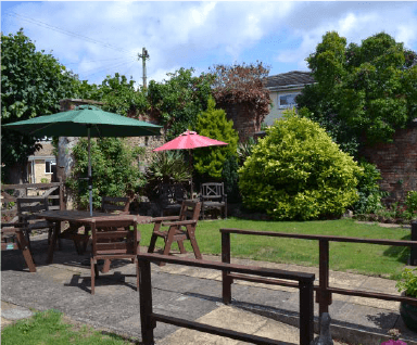 The enclosed garden with seating and parasols at Fairholme House